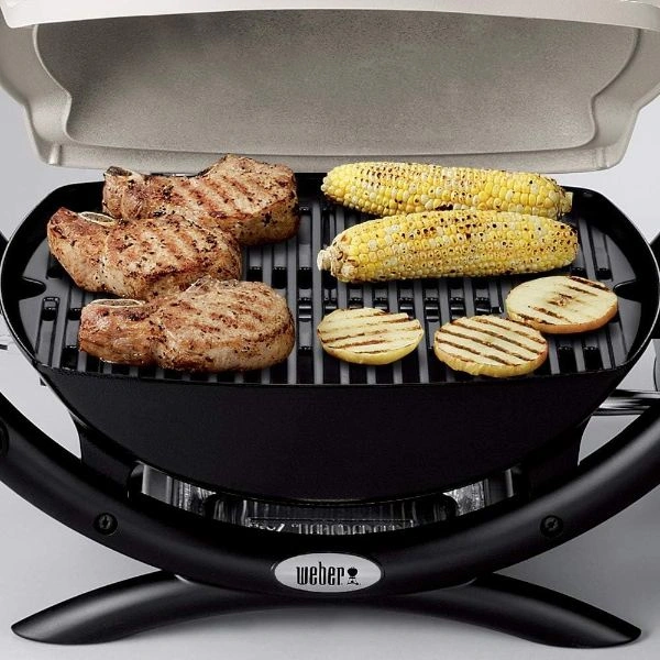 Bucati de carne, cartofi si porumb pe grilajul gratarului pe gaz Weber Q1000